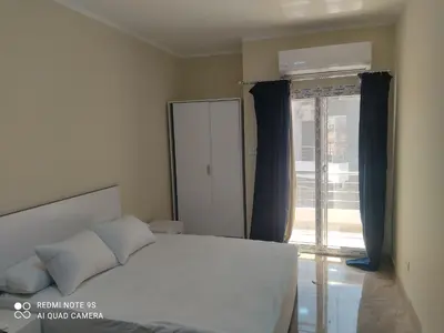 a bedroom with a bed and a large window at Magawish District in Hurghada