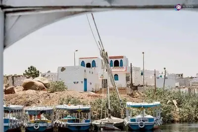 a group of boats are docked in front of a building at Malika nubian house in Aswan