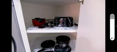 a cupboard with a tea pot and dishes in it at La bonita one bedroom apartment in Hurghada