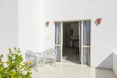 a room with two white chairs and a table at La bonita one bedroom apartment in Hurghada