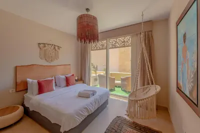 a bedroom with a bed and a large window at Fresh & Modern 1BR in El Gouna. Mangroovy Pool & Beach in Hurghada
