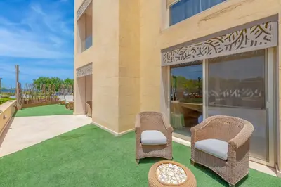 a patio with two wicker chairs and a table at Fresh & Modern 1BR in El Gouna. Mangroovy Pool & Beach in Hurghada