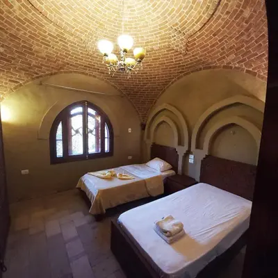 a bedroom with two beds and a chandelier at Mystical habou domes villa private pool in Luxor