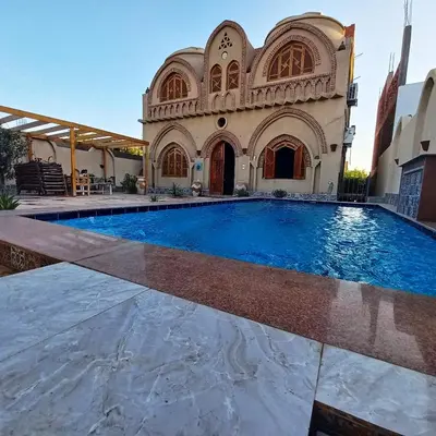 a large swimming pool in front of a building at Mystical habou domes villa private pool in Luxor