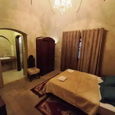 a bedroom with a bed and a mirror and a chandelier at Mystical habou domes villa private pool in Luxor