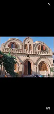 a large building with a clock on top of it at Mystical habou domes villa private pool in Luxor