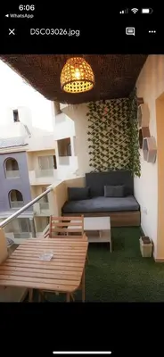 a balcony with a couch and tables and a light at Benashti Hurghada apartment in Hurghada