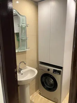 a bathroom with a sink and a washing machine at Benashti Hurghada apartment in Hurghada