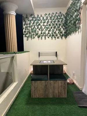 a room with a table and green carpet at Benashti Hurghada apartment in Hurghada
