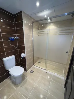 a bathroom with a toilet and a glass shower at Benashti Hurghada apartment in Hurghada