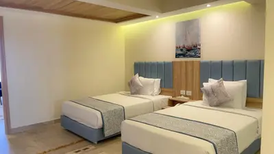 a room with two beds and a painting on the wall at Jasmine Palace Resort in Hurghada