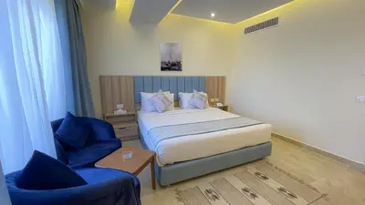 a bedroom with a bed and a blue chair at Jasmine Palace Resort in Hurghada