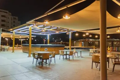 an outdoor patio with tables and chairs and lights at Scandic resort 547 in Hurghada