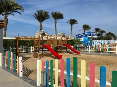 a playground with a colorful fence and palm trees at Scandic resort 547 in Hurghada