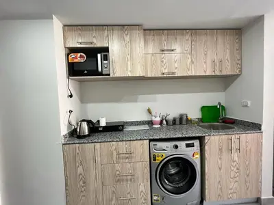 a kitchen with a washing machine and a microwave at Scandic resort 547 in Hurghada