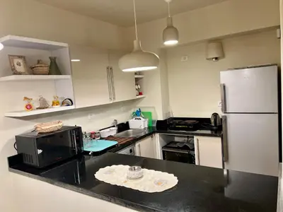 a kitchen with a black counter top with a refrigerator at veranda sahl hasheesh in Hurghada