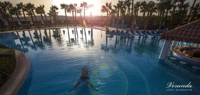 a woman swimming in a swimming pool at a resort at veranda sahl hasheesh in Hurghada