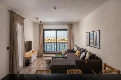 a living room with a couch and a large window at Creek Hotel and Residences El Gouna in Hurghada