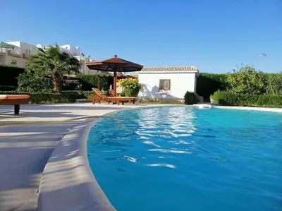 a swimming pool with blue water in front of a house at Hurghada-Magawish Studio 2 in Hurghada