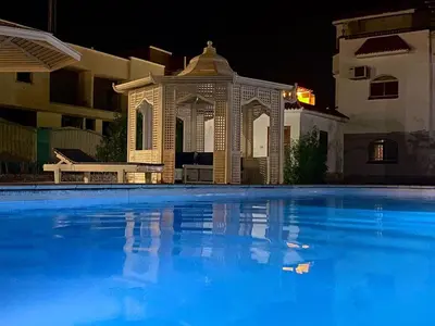 a swimming pool in front of a building at night at Hurghada-Magawish Studio 2 in Hurghada