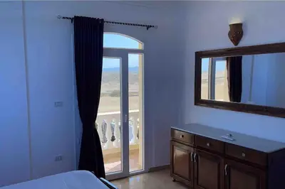 a bedroom with a large window and a mirror at Sunshine villa ( south Safaga ) in Safaga