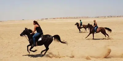 a group of people riding horses in the desert at Sunshine villa ( south Safaga ) in Safaga