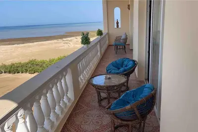 a balcony with chairs and a table and the beach at Sunshine villa ( south Safaga ) in Safaga