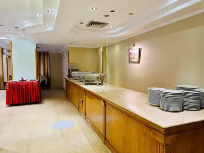 a restaurant with a counter with plates on it at Queens Valley Hotel in Luxor