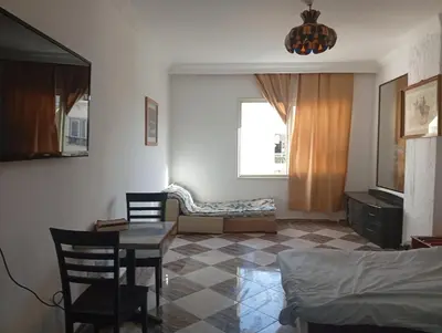 a living room with a bed and a table and chairs at Entertainment Central Location in Hurghada