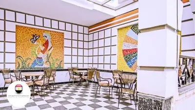 a restaurant with tables and chairs and mosaics on the wall at Entertainment Central Location in Hurghada