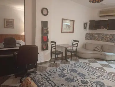 a bedroom with a bed and a couch and a table at Entertainment Central Location in Hurghada