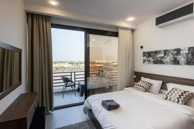 a bedroom with a bed and a balcony at SOLA INN Hotel Hurghada in Hurghada