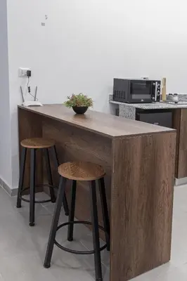 a kitchen with a wooden island with two stools at SOLA INN Hotel Hurghada in Hurghada