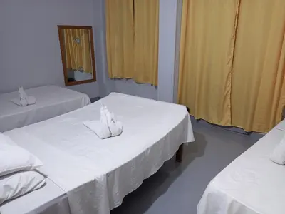 a room with two beds with white sheets and a mirror at Bob Marley Peace hotel luxor in Luxor