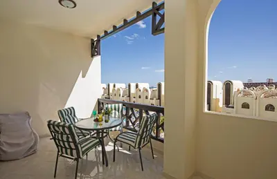 a balcony with a table and chairs and a window at Buki-Gravity-Homes, Ap No2, seaview , HEATED pool, 5 star resort Gravity Sahl Hasheesh-FOR GUESTS WITH NONEGYPTIAN PASSPORTS in Hurghada