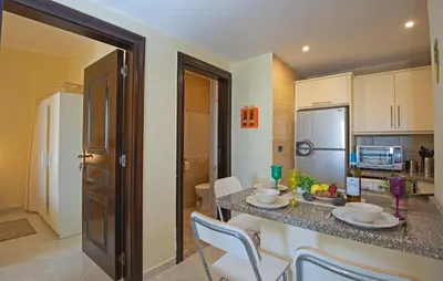 a kitchen with a counter with chairs and a table at Buki-Gravity-Homes, Ap No2, seaview , HEATED pool, 5 star resort Gravity Sahl Hasheesh-FOR GUESTS WITH NONEGYPTIAN PASSPORTS in Hurghada