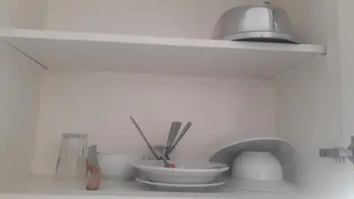 a shelf with bowls and utensils on a kitchen counter at One room in a compound with the swimming pool in Hurghada
