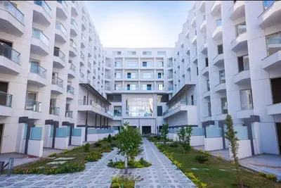 an apartment building with a garden in front of it at Scandic Resort Hurghada in Hurghada