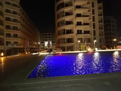 a swimming pool in front of some buildings at night at Scandic Resort Hurghada in Hurghada