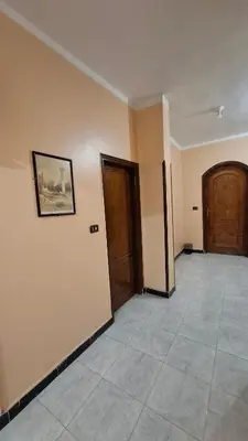 an empty room with two doors and a tile floor at West Bank Guest House in Luxor