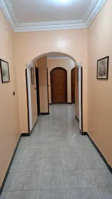 an empty hallway with a door and a tile floor at West Bank Guest House in Luxor