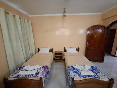two beds sitting in a room with at West Bank Guest House in Luxor