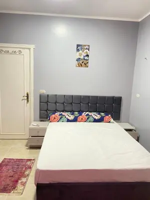 a bedroom with a large bed with a black headboard at Red Ruby Compound منتجع الياقوتة الحمراء in Hurghada