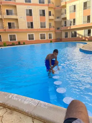 a young boy playing with frisbees in a swimming pool at Red Ruby Compound منتجع الياقوتة الحمراء in Hurghada