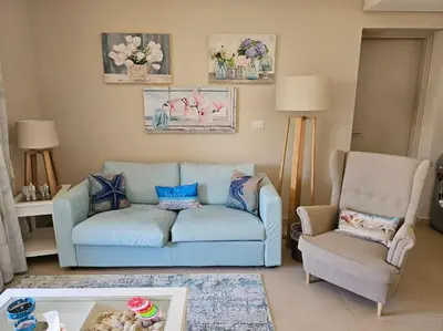 a living room with a blue couch and a chair at Mangroovy- 1BR Bleu Ciel in Hurghada