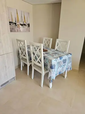 a dining room table with four chairs and a blue and white table cloth at Mangroovy- 1BR Bleu Ciel in Hurghada