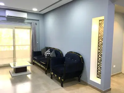 a living room with two chairs and a table at Villa Elkoumy Apartments in Luxor