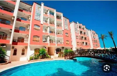 a large apartment building with a bridge over a swimming pool at وحدة فندقية سياحية بكمبوانداند وسط الغردقة in Hurghada