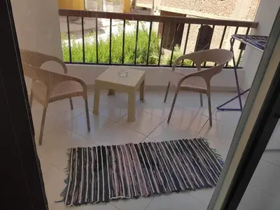 a balcony with chairs and a table and a rug at وحدة فندقية سياحية بكمبوانداند وسط الغردقة in Hurghada