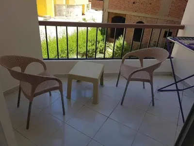 a balcony with two chairs and a table and a window at وحدة فندقية سياحية بكمبوانداند وسط الغردقة in Hurghada